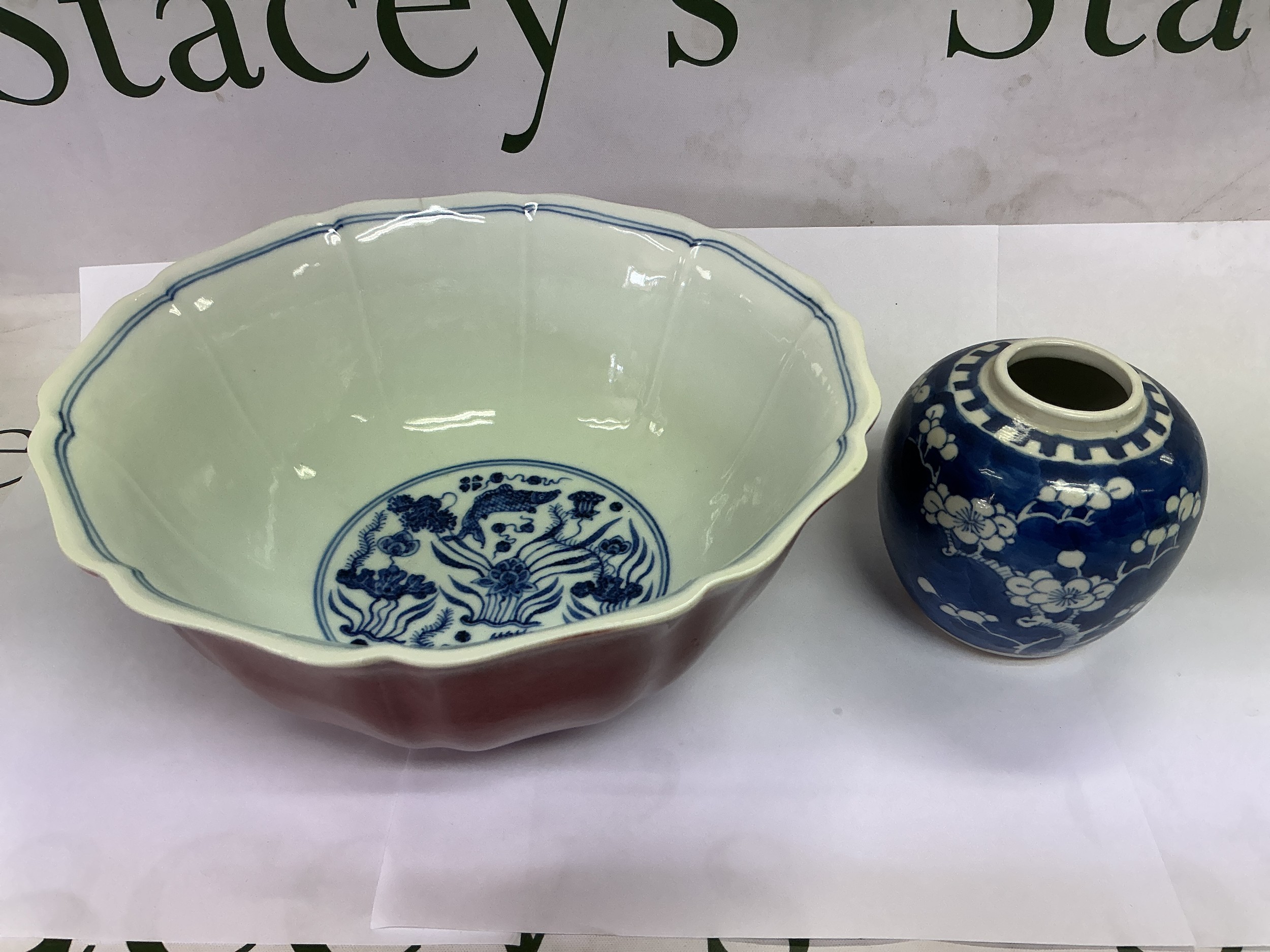 A Chinese sang de bouef bowl with fluted sides and decorated with fish to the interior, approx diameter 22cm. Comes with a blue and white ginger jar decorated with prunus blossom (2).