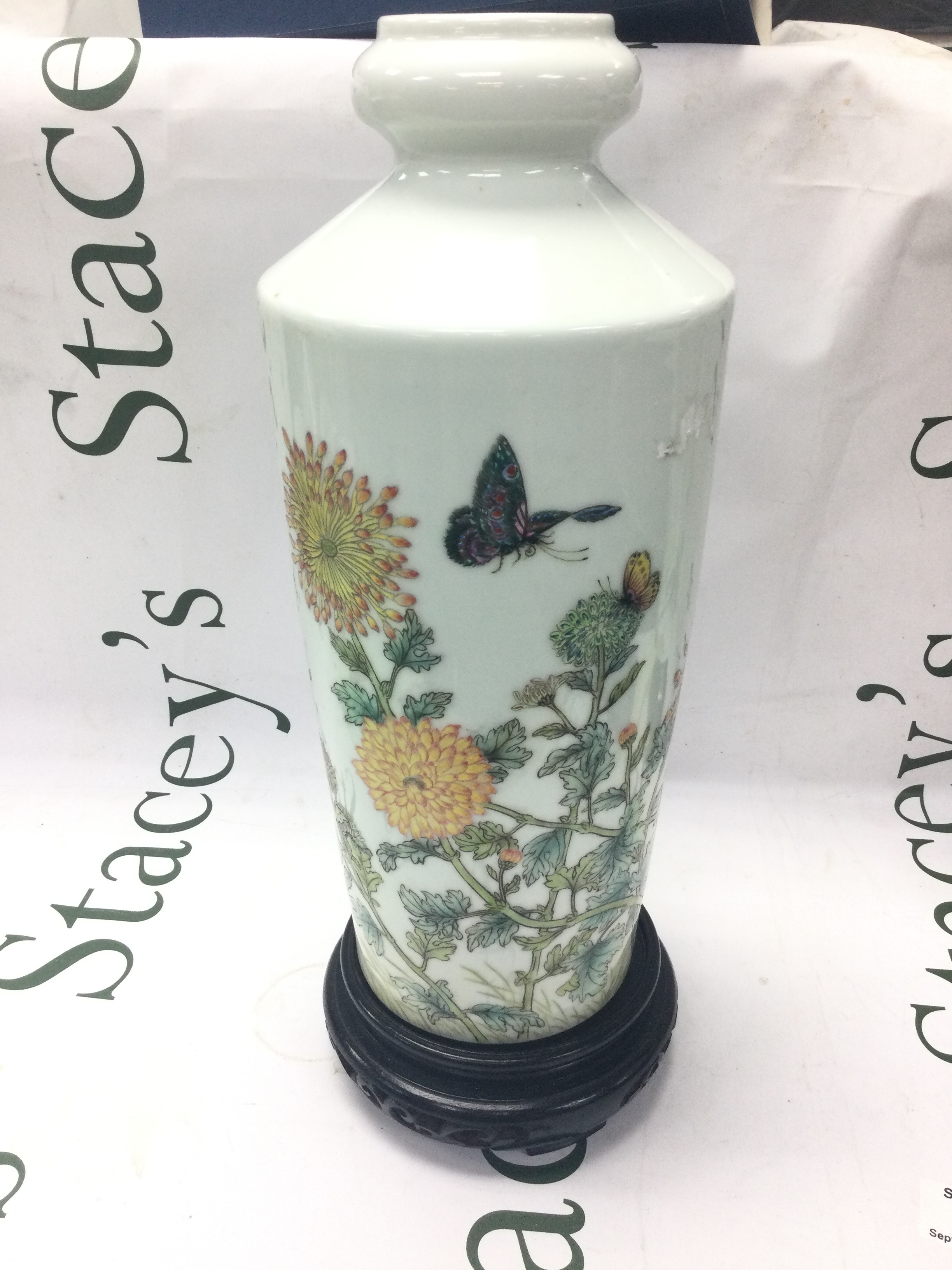 A Chinese porcelain vase decorated in polychrome enamels with chrysanthemum blossoms and butterflies. 32cm tall