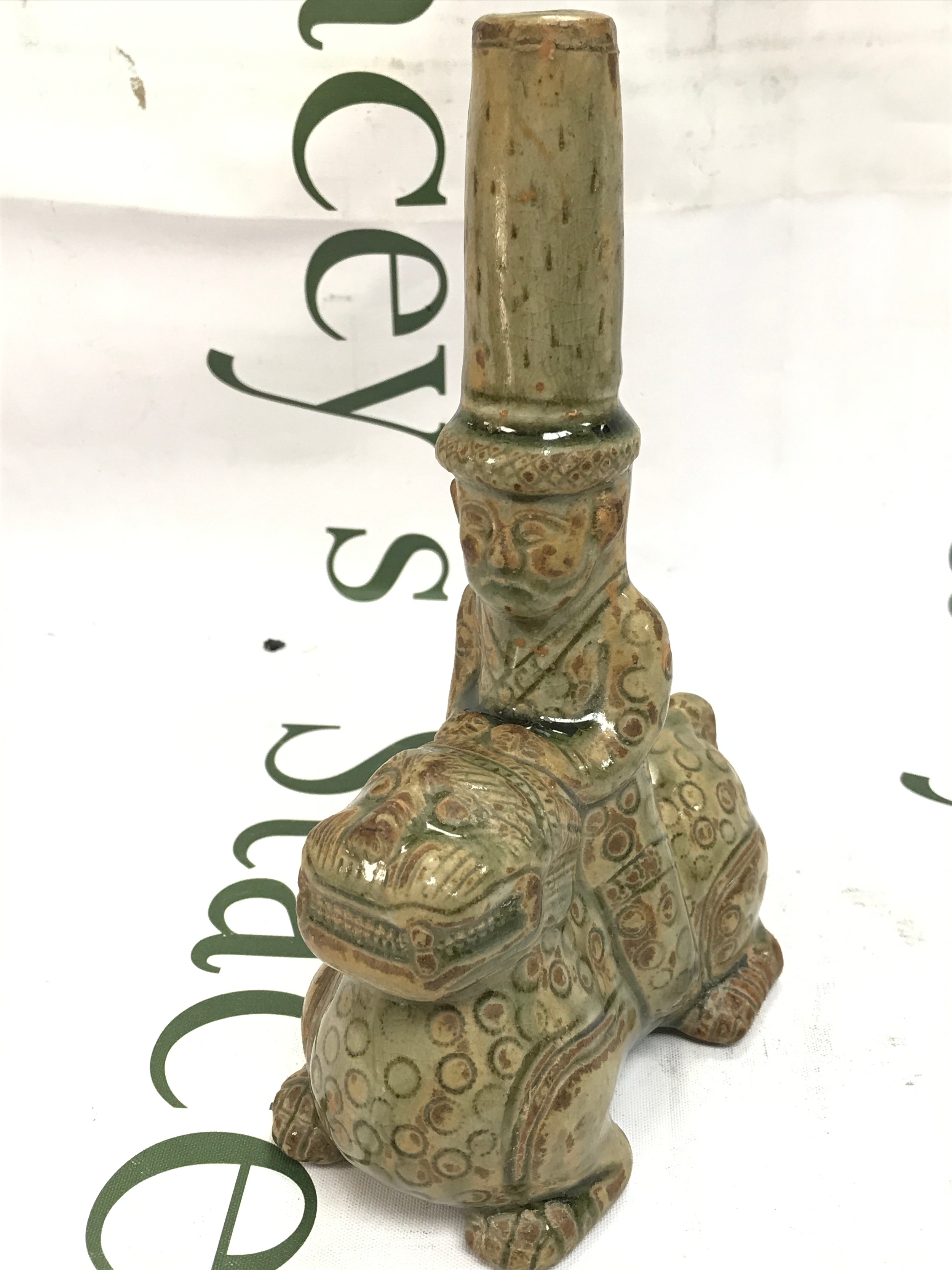 A Chinese ceramic figurine depicting a rider on a mythical beast , in the manner of historical artefacts from the six dynasties or western Jin dysnasty, 20cm high 