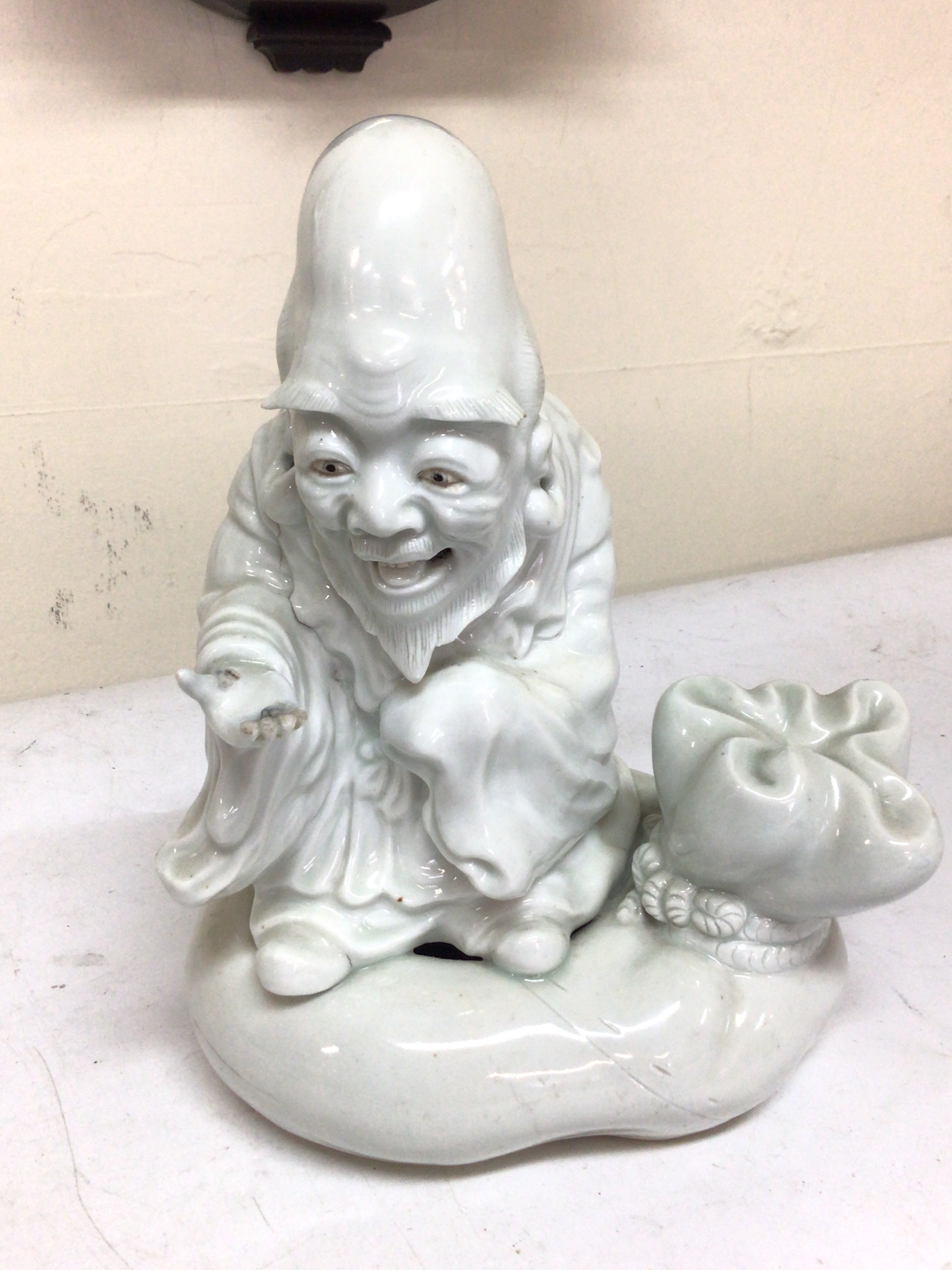 A Chinese blanc de Chine figure of a sage Shoulao on a shaped sack like base possible 19th century height 24cm damage to the fingers