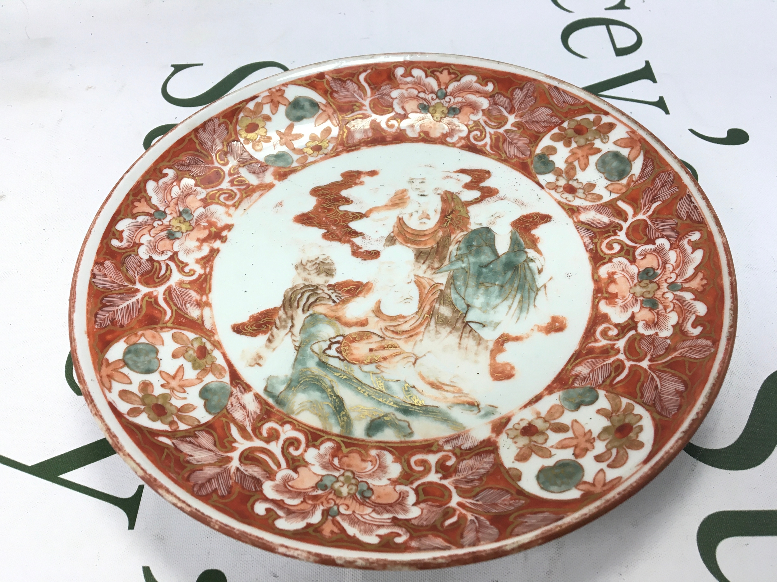 A Chinese red and white dish with figure decorated reversed with 9 character mark. 21cm wide