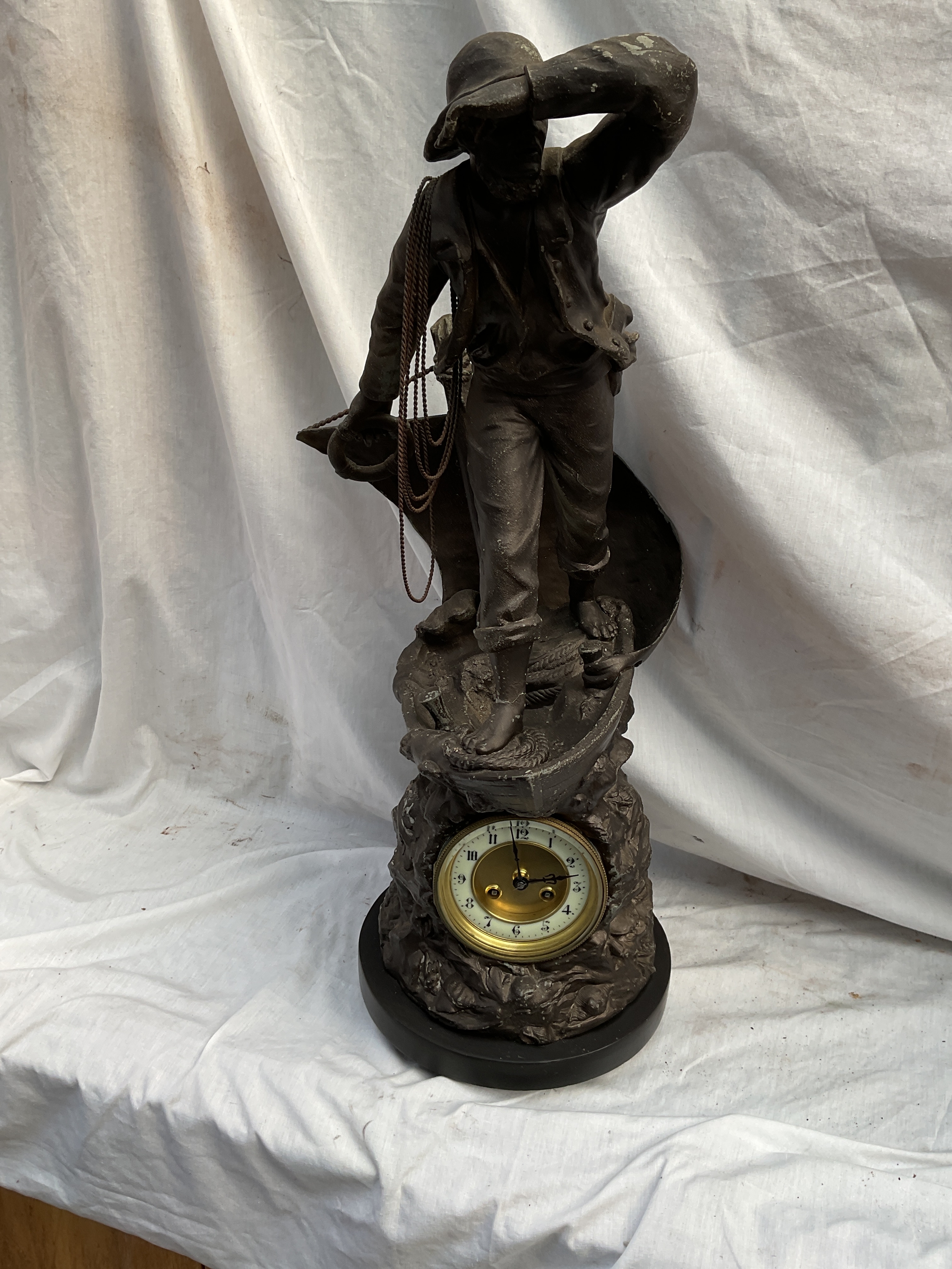 19th C large spelter clock of a mariner on a boat,with a base decorated with shells and crab, and an eight day movement by Marti bronze award striking on a bell, with pendulum. H67 cm.