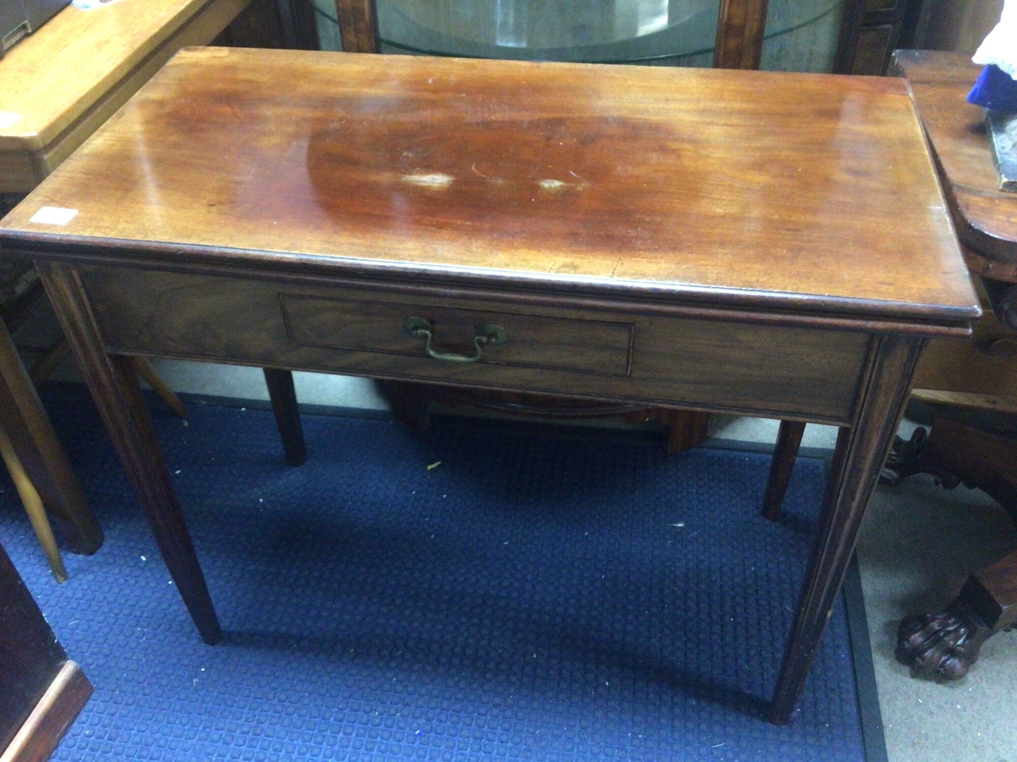 A George III mahogany tea table the twin flap top above a single drawer on square tapering legs. Width 90cm x 46cm TO BE SOLD WITHOUT RESERVE