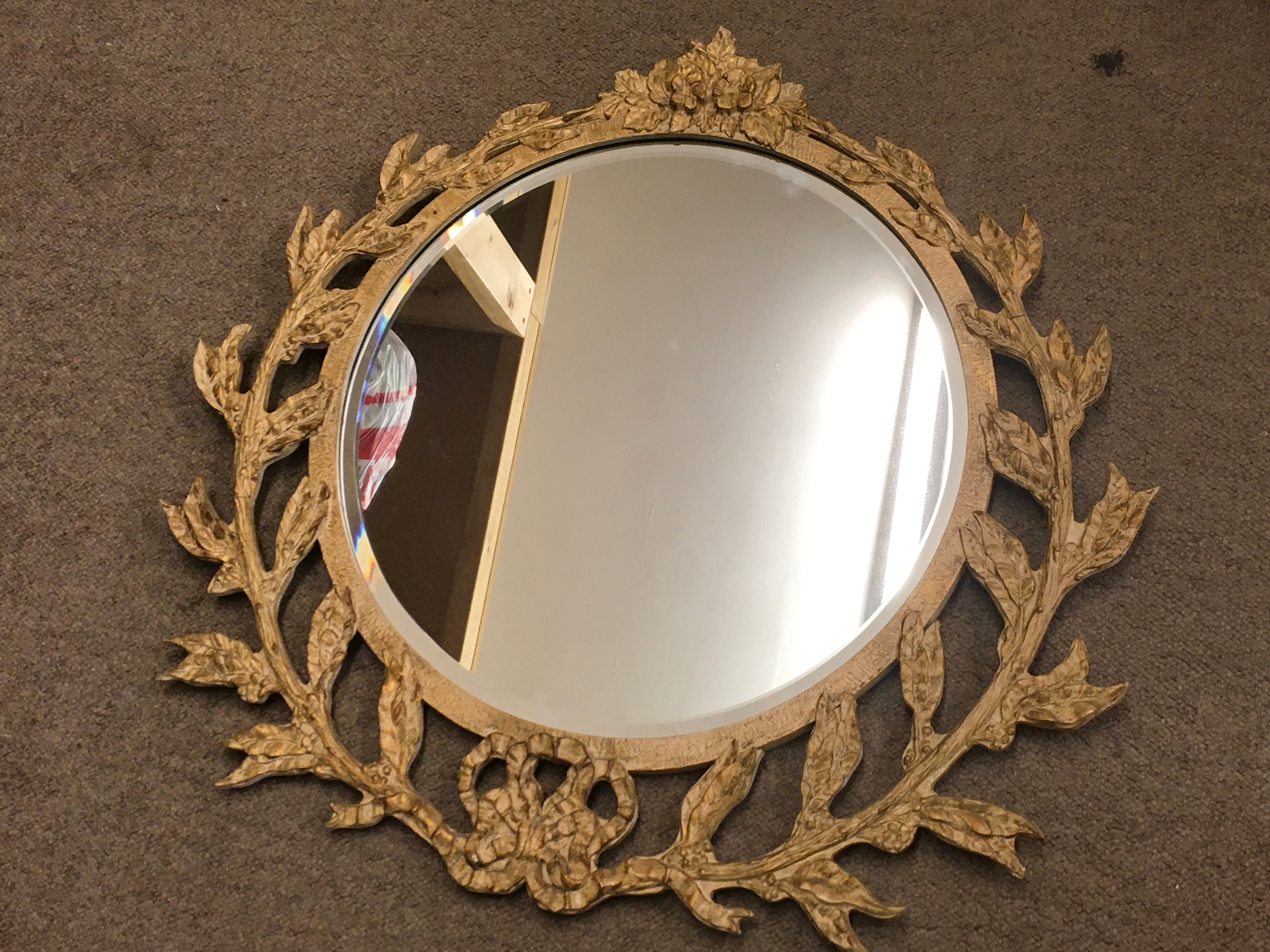 A composite mirror with leaf / foliage design 68cm wide 64cm tall
