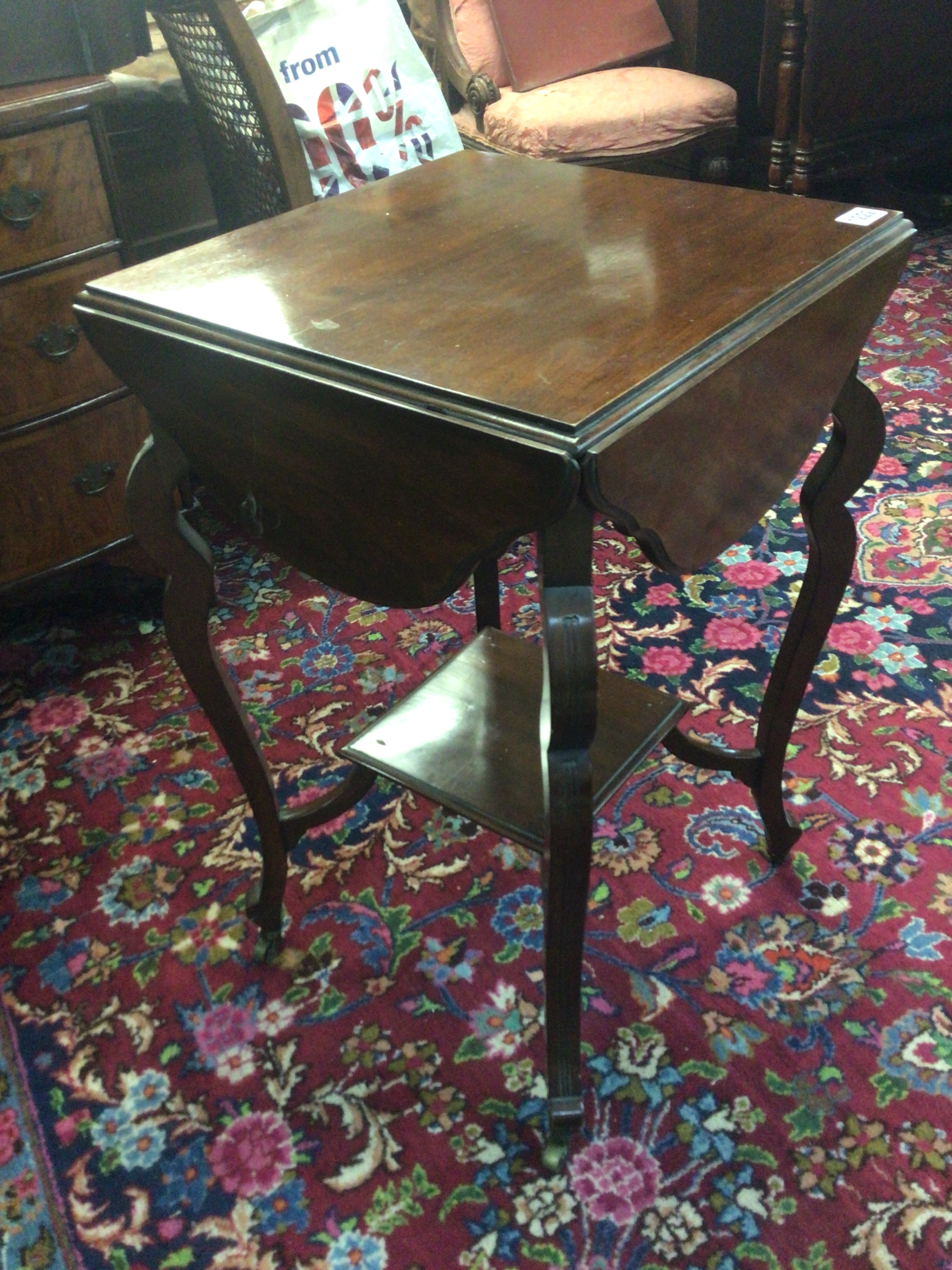 An Edwardian walnut occasional table with a shaped top with four hinged leaves on cabriole legs. TO BE SOLD WITHOUT RESERVE