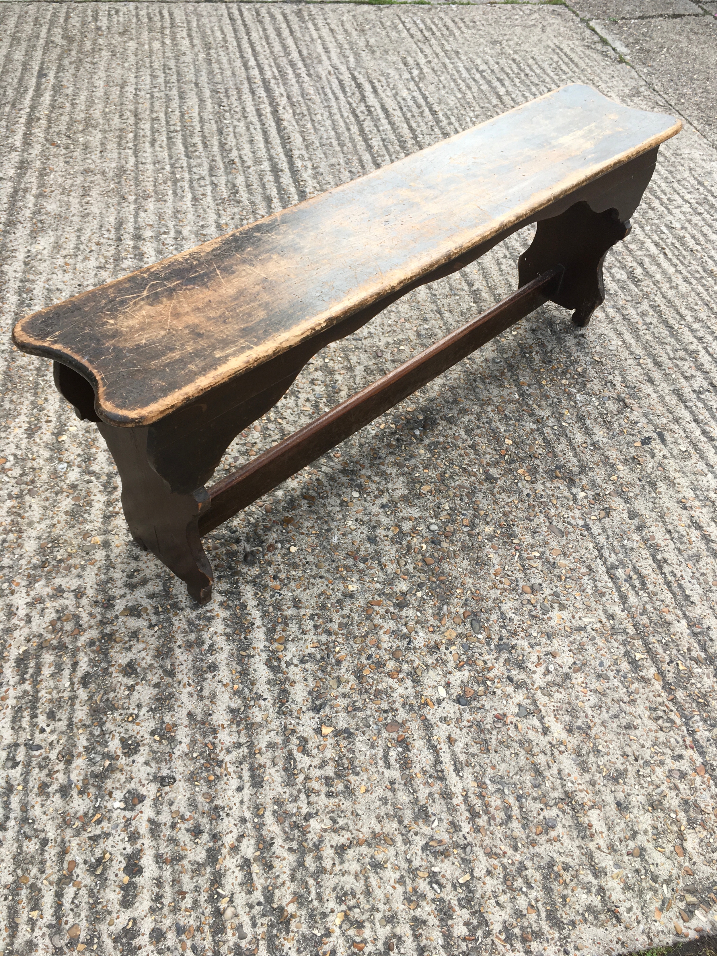 A stained pine vernacular bench