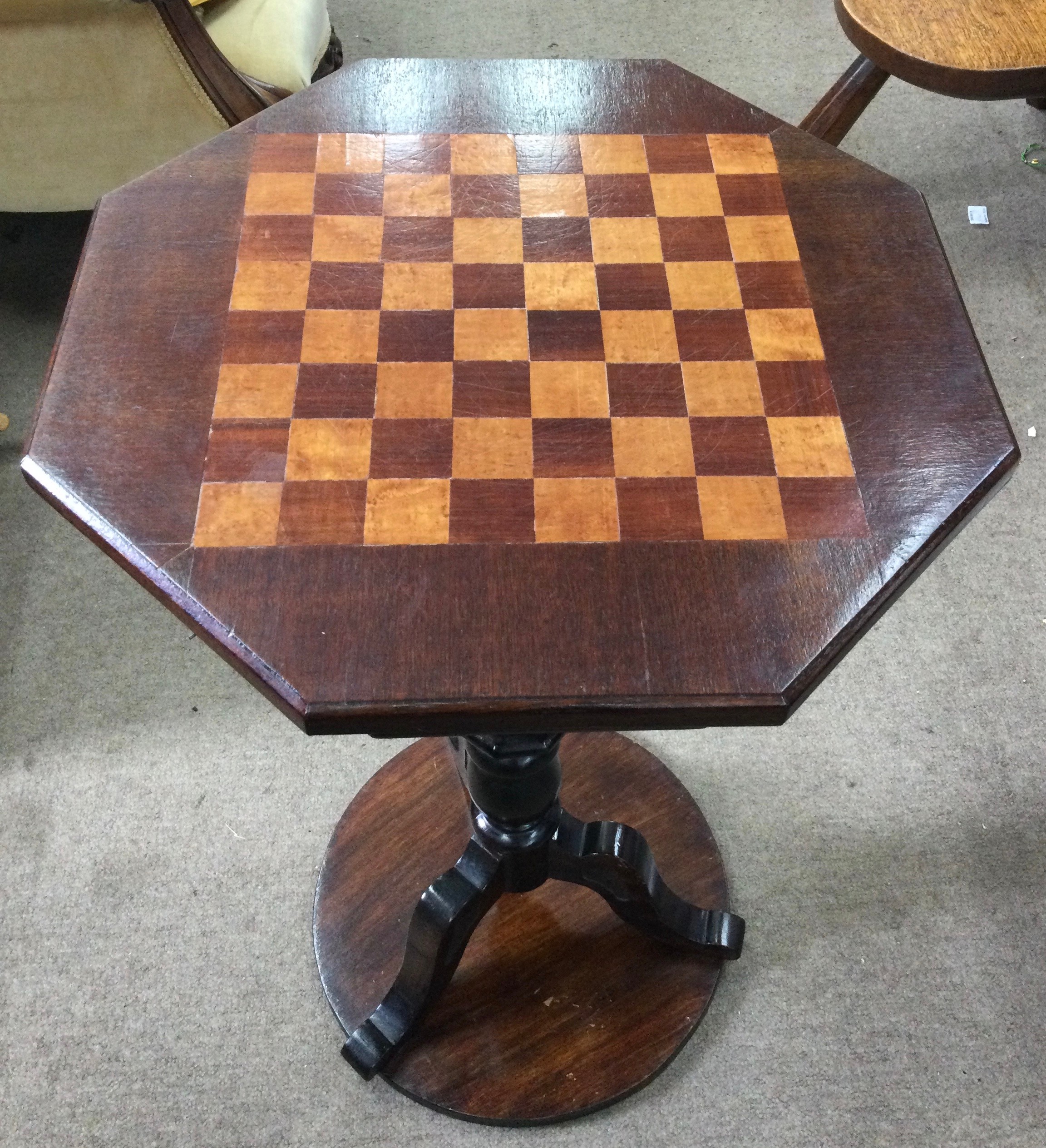 A hexagonal games table with chequerboard top on tripod base