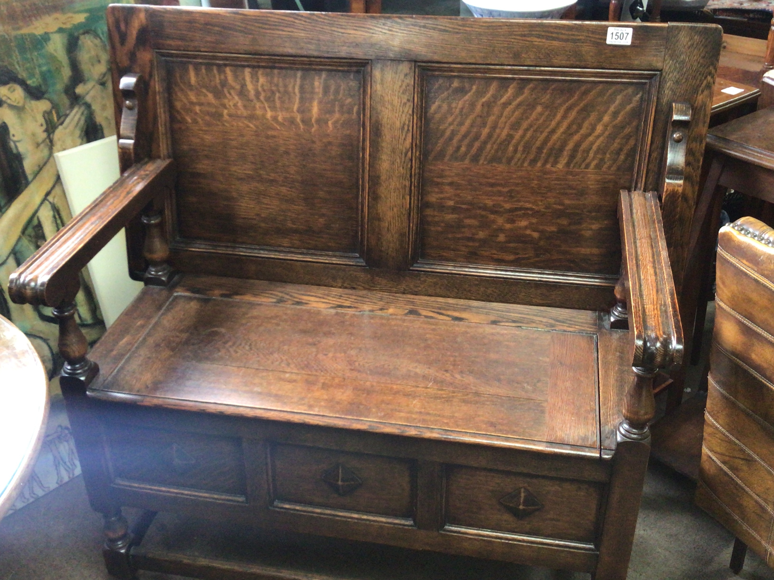 An oak hall seat with a hinged back and seat open arms.length 106cm