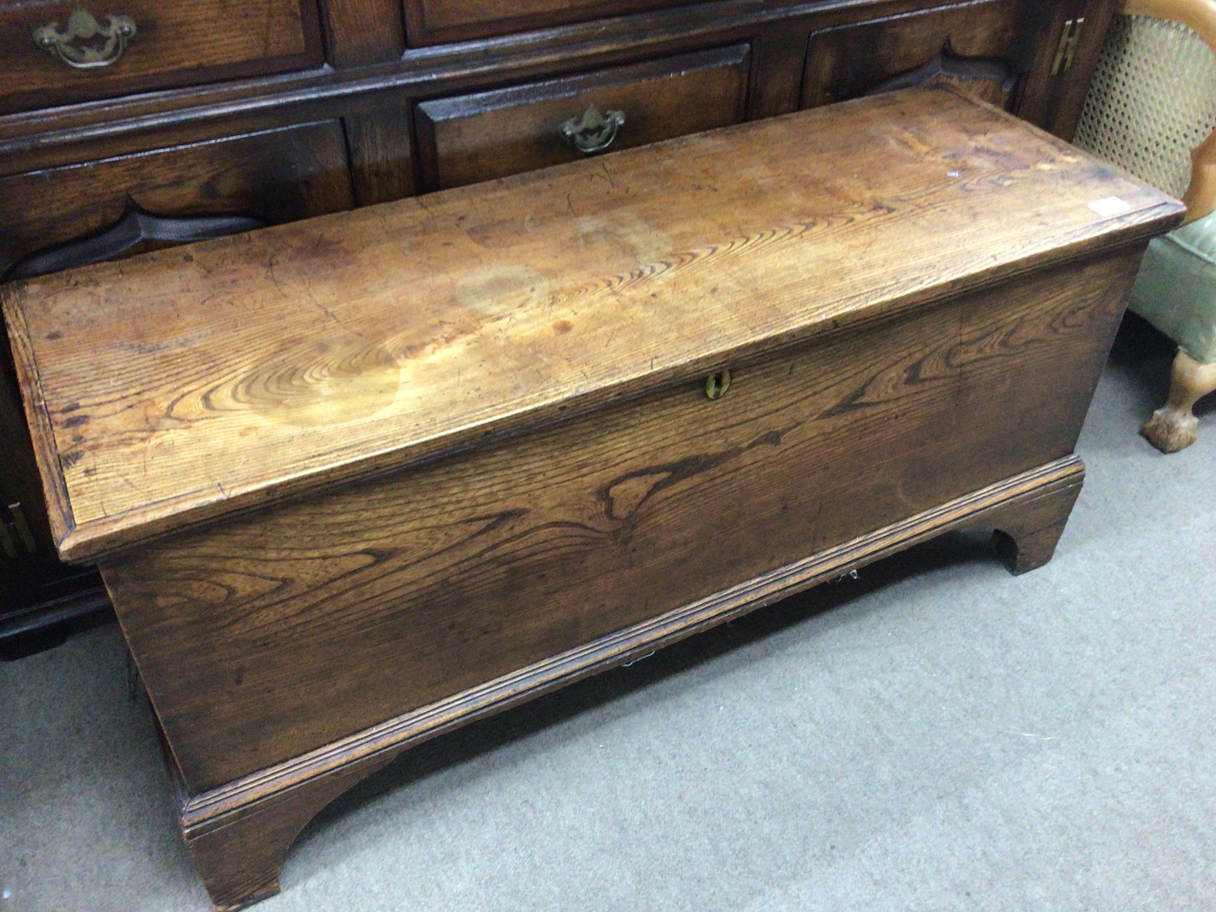  A 19th Elm vernacular chest of rectangular shape with a hinged top on bracket feet. 115x40cm 