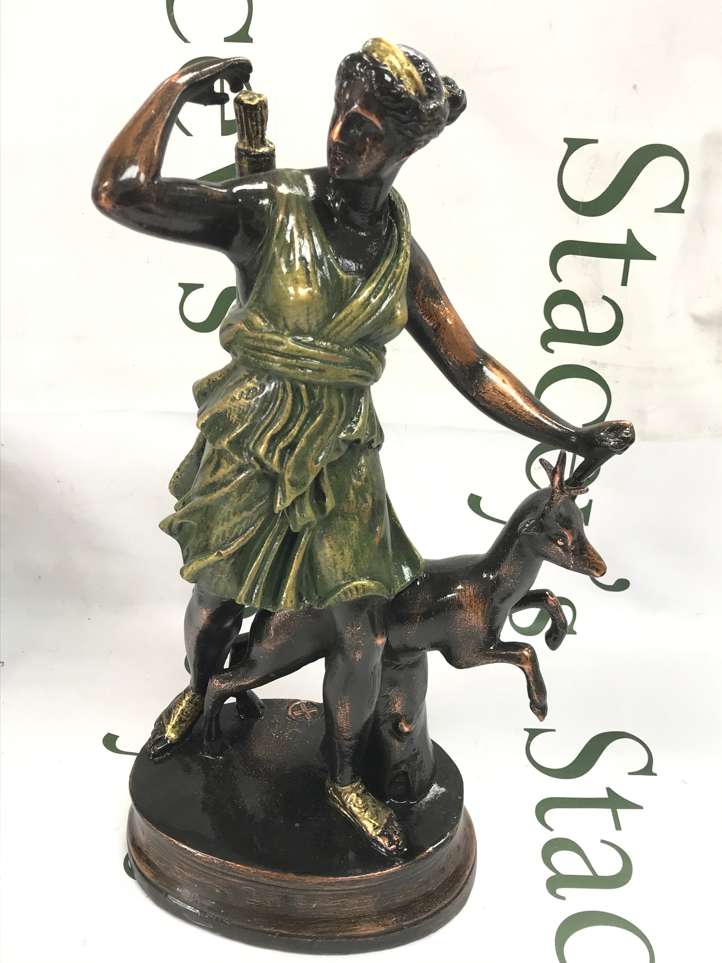 A metal cast figure of Diana the Huntress with a deer, modelled after the famous classical antique statue known as the Diana of Versailles. 35cm tall