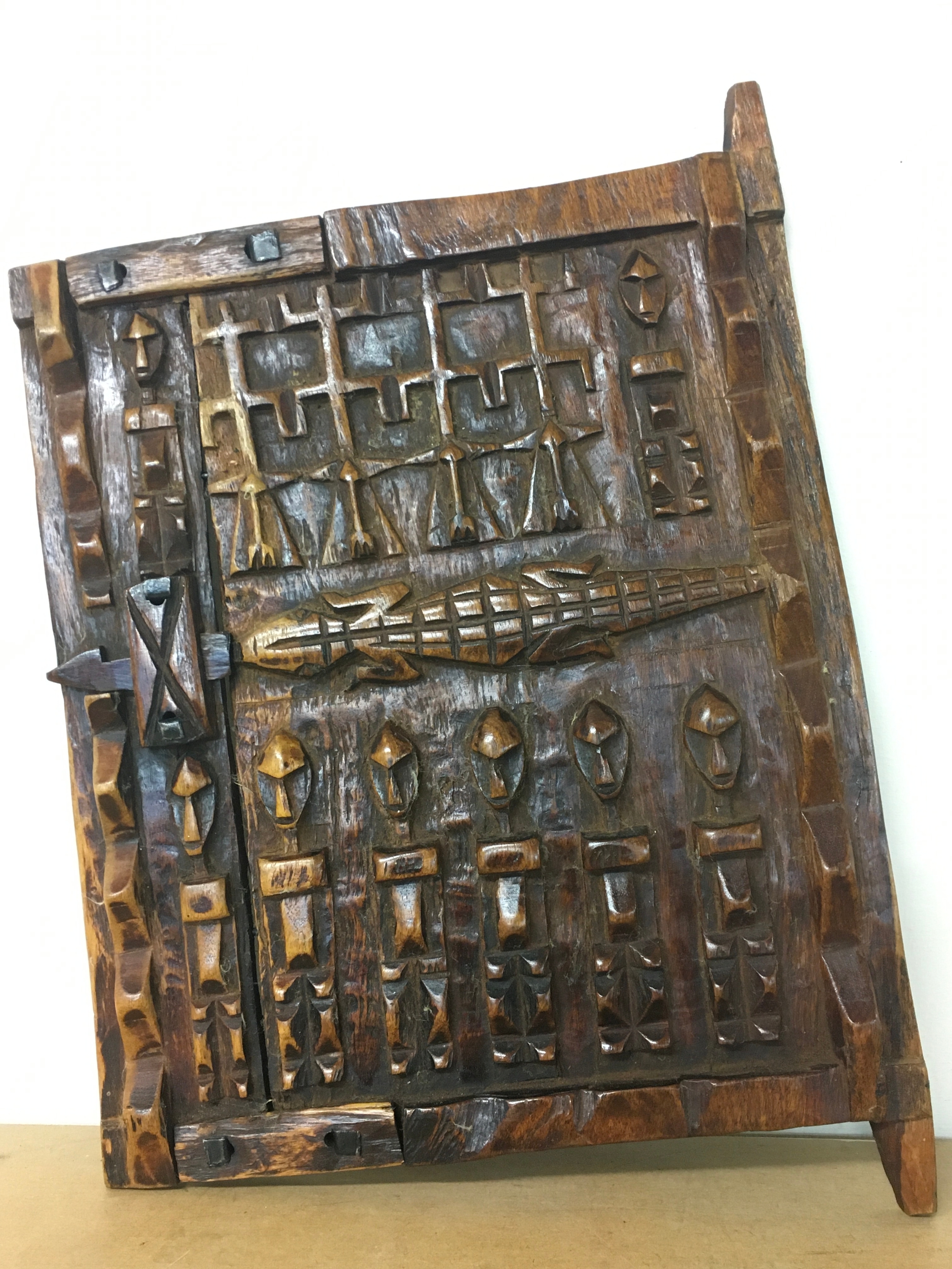 A hand-carved wooden Dogon granary door from Mali, West Africa, featuring traditional ancestral figures and a central crocodile carving 35cm wide 48cm tall