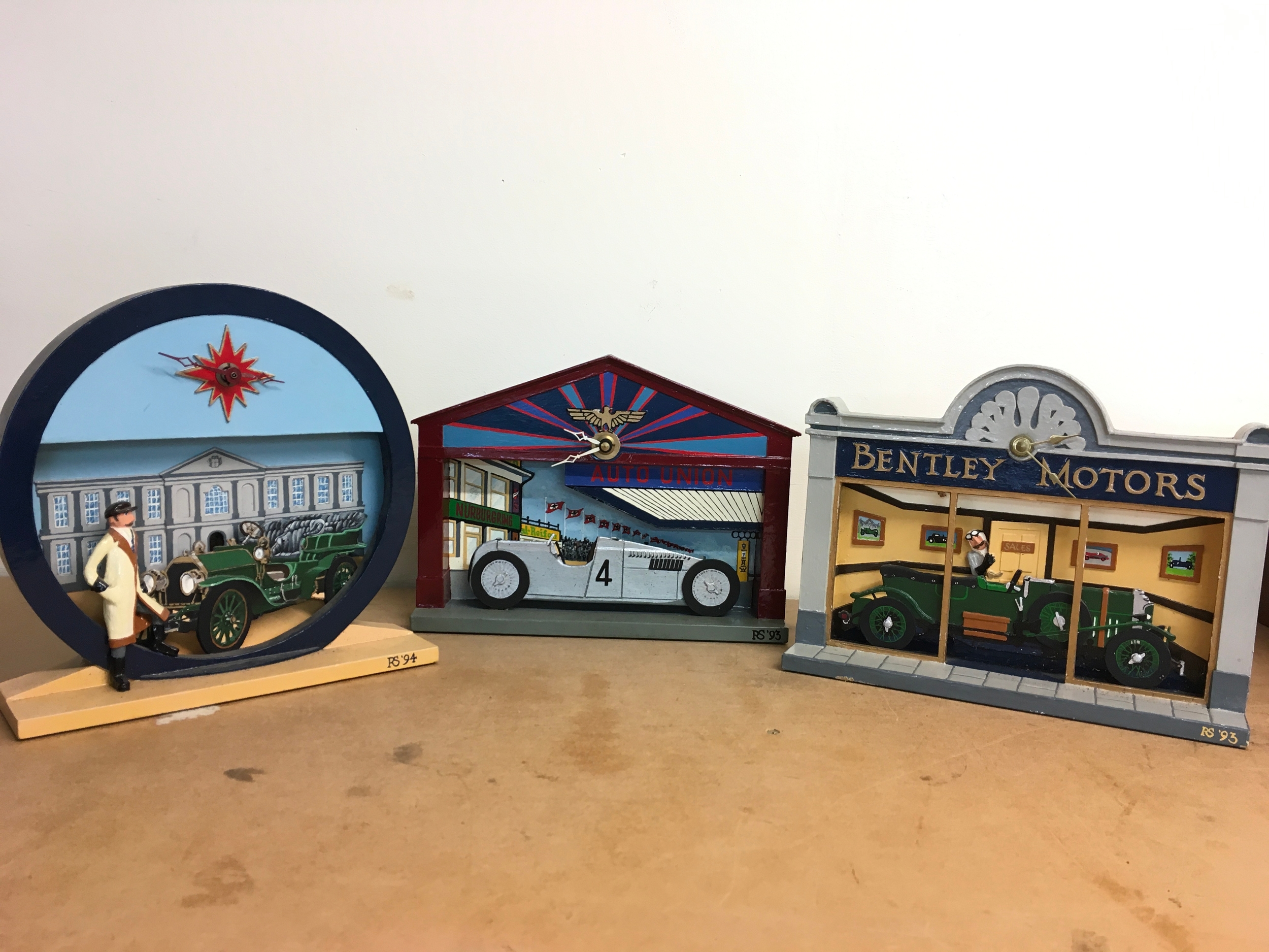 Three hand crafted and painted battery operated classic car clocks. Biggest 22cm tall 22cm wide 