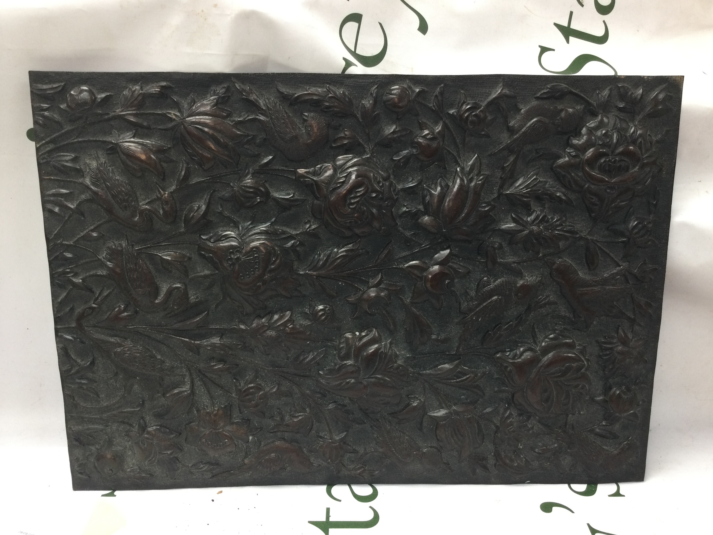 A pressed bronzed metal plaque. 