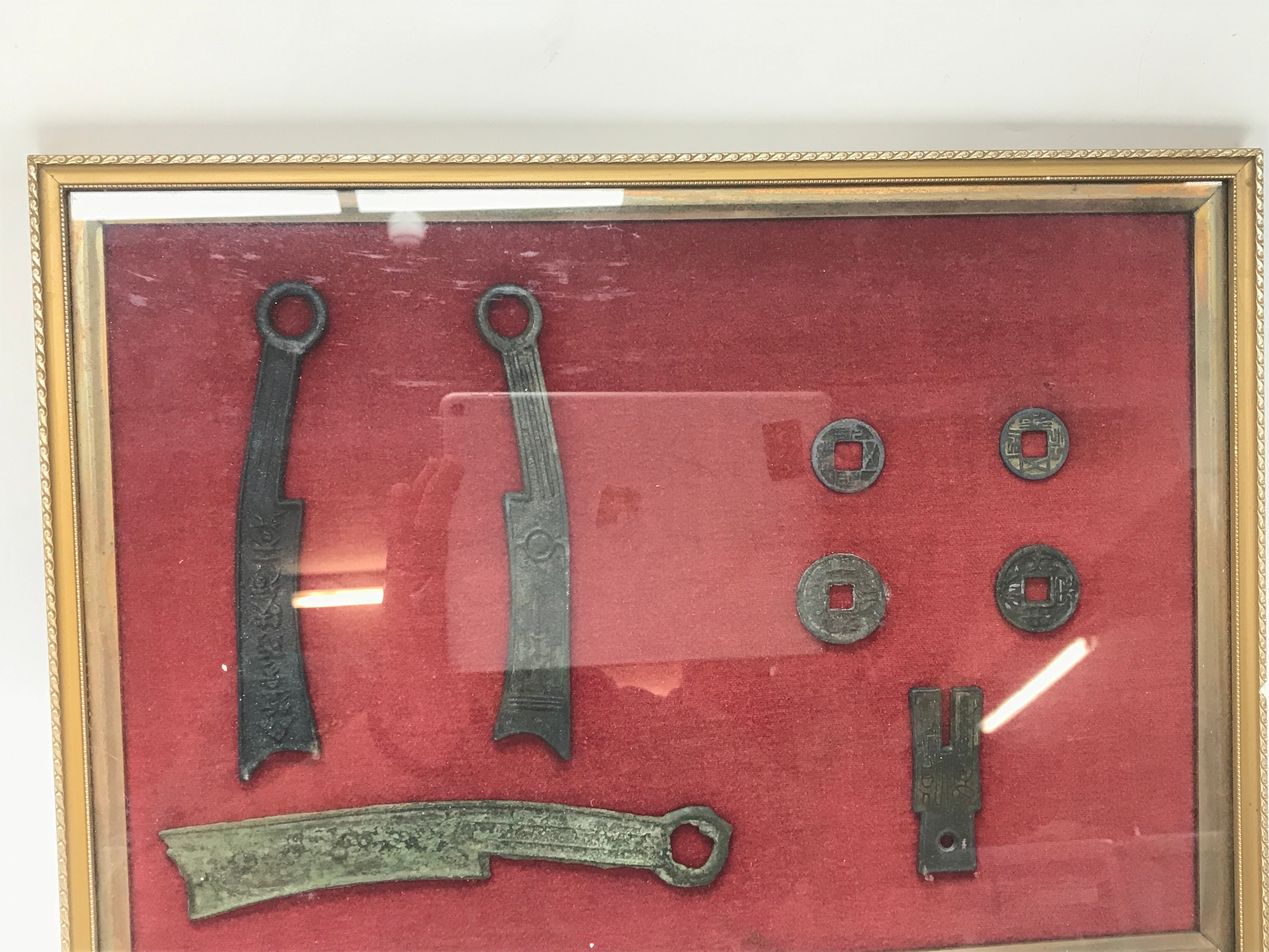 Framed collection appears to display ancient Chinese bronze Knife money and spade money dating back to the Zhou dynasty.