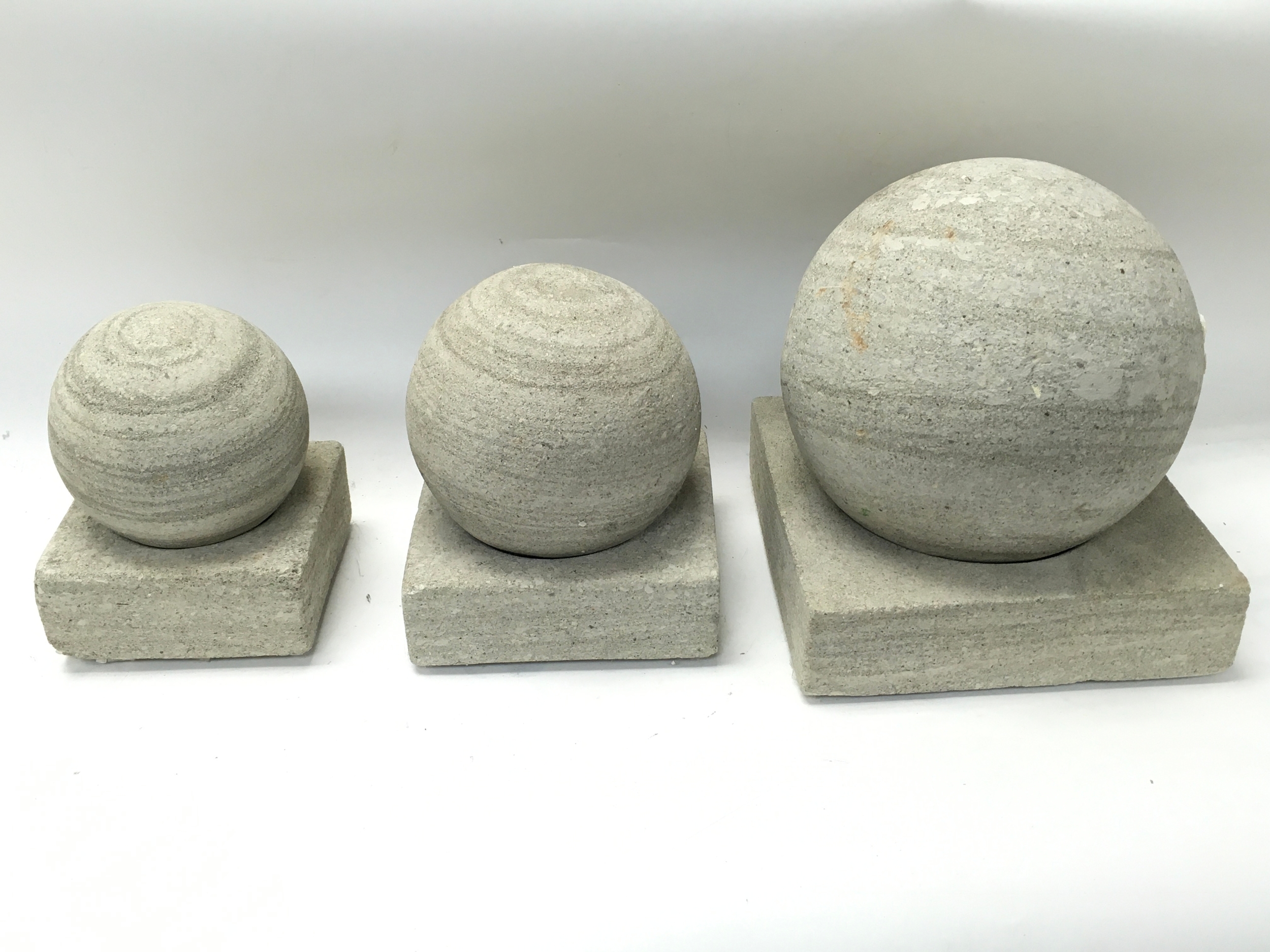 Three stone balls and plinths tallest Approx 23cm