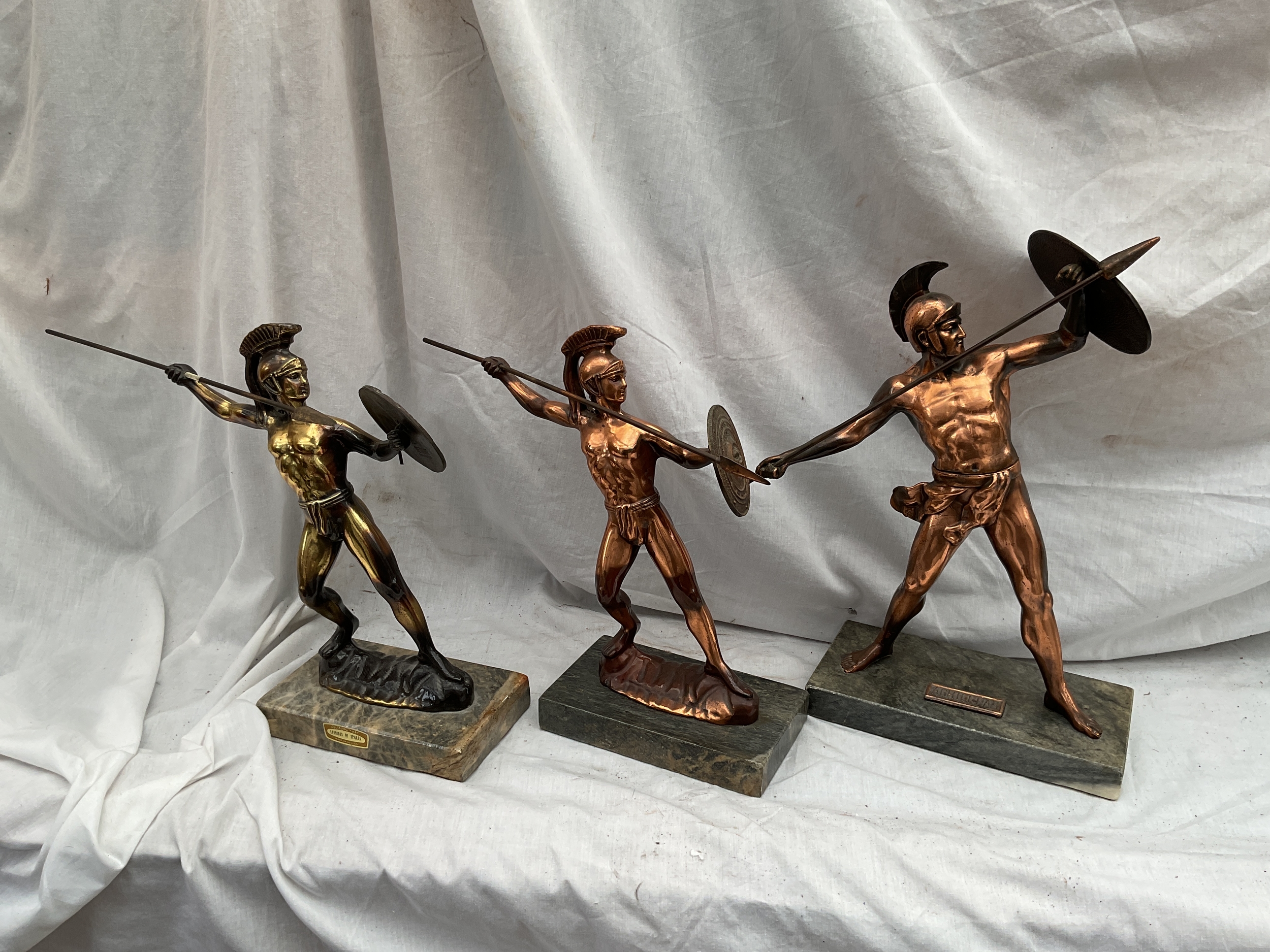 Three Greek Warrior figures on is named as Achilles.on marble plinths.