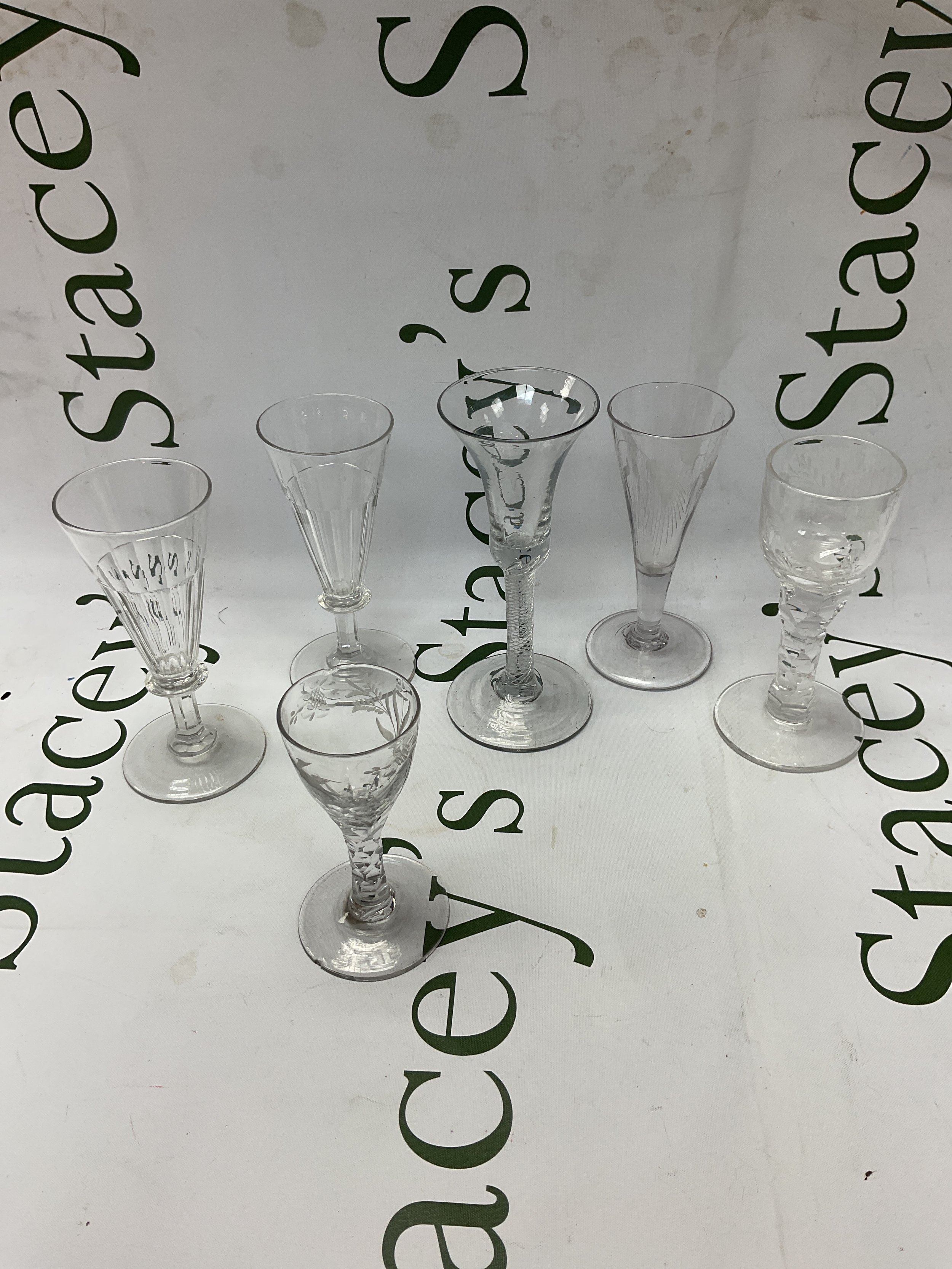 Six 19th c glasses, with engraved bowls, faceted stems and air twist stems.
