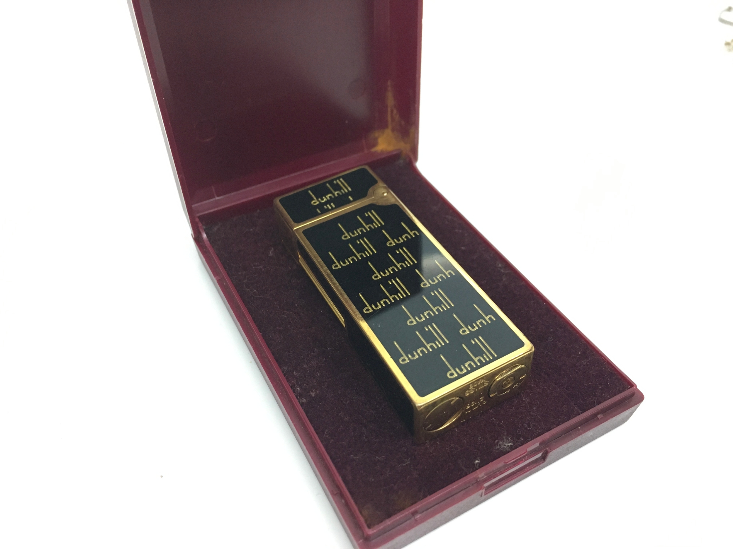 A Rollagas gas lighter featuring a black lacquer finish with gold-plated accents and a repeating logo pattern NO RESERVE