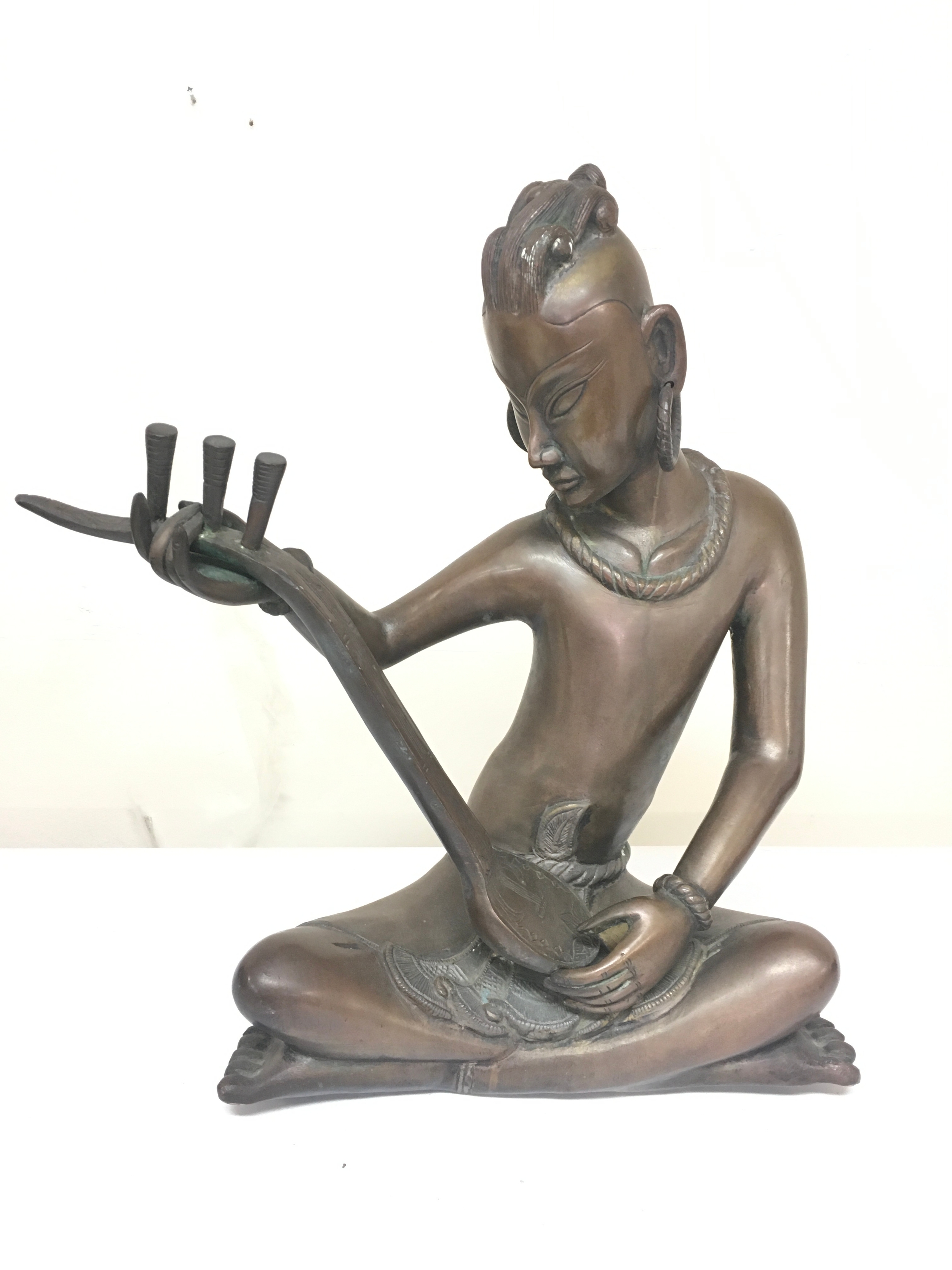 A large bronze seated tribal musician figure 47cm tall
