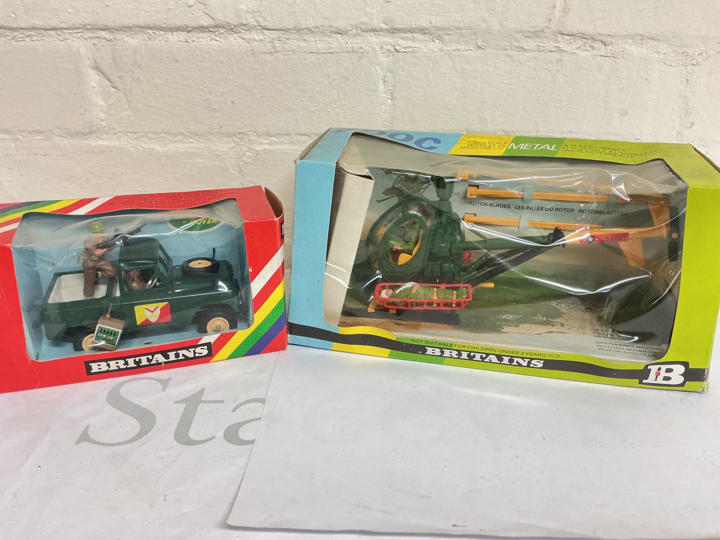 A Boxed Britains Military Land Rover #9782 And A Hughes's 300c #9761. And A Pack Of Vehicle Loads