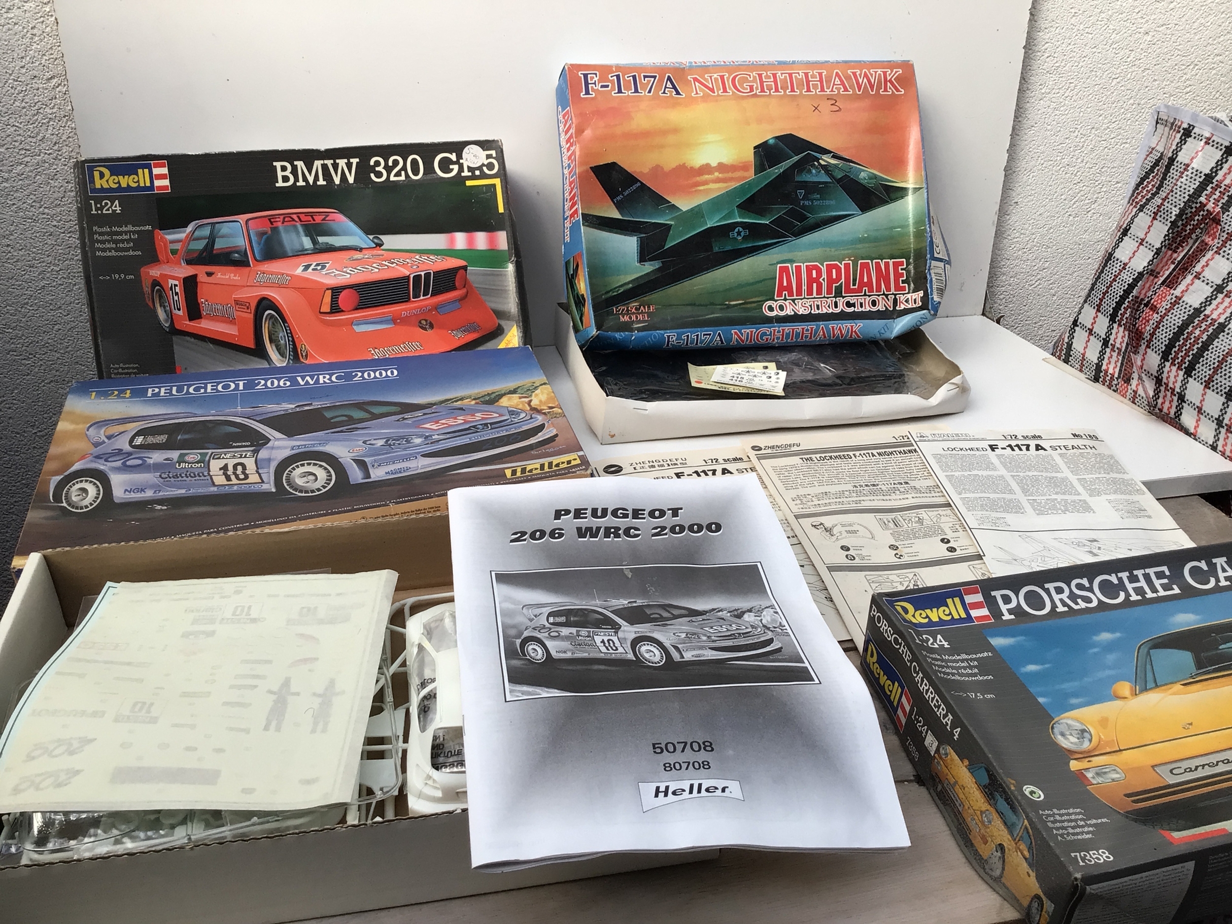 A box containing a collection of boxed model kits featuring aircraft and cars in a variety of scales.  Manufacturers include Revell, Heller, Academy.  No reserve