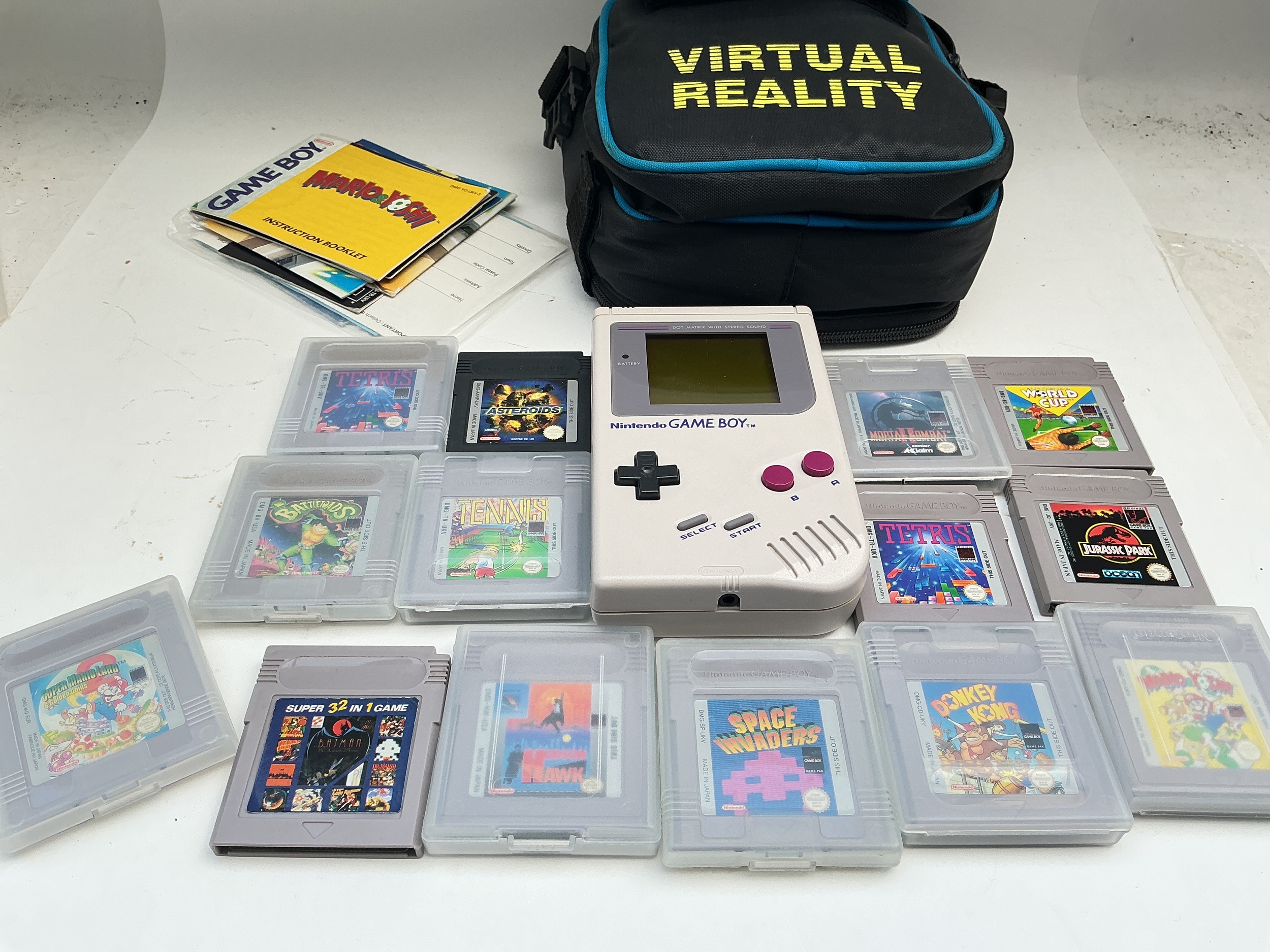 A Nintendo Game Boy And A Collection Of Games.
