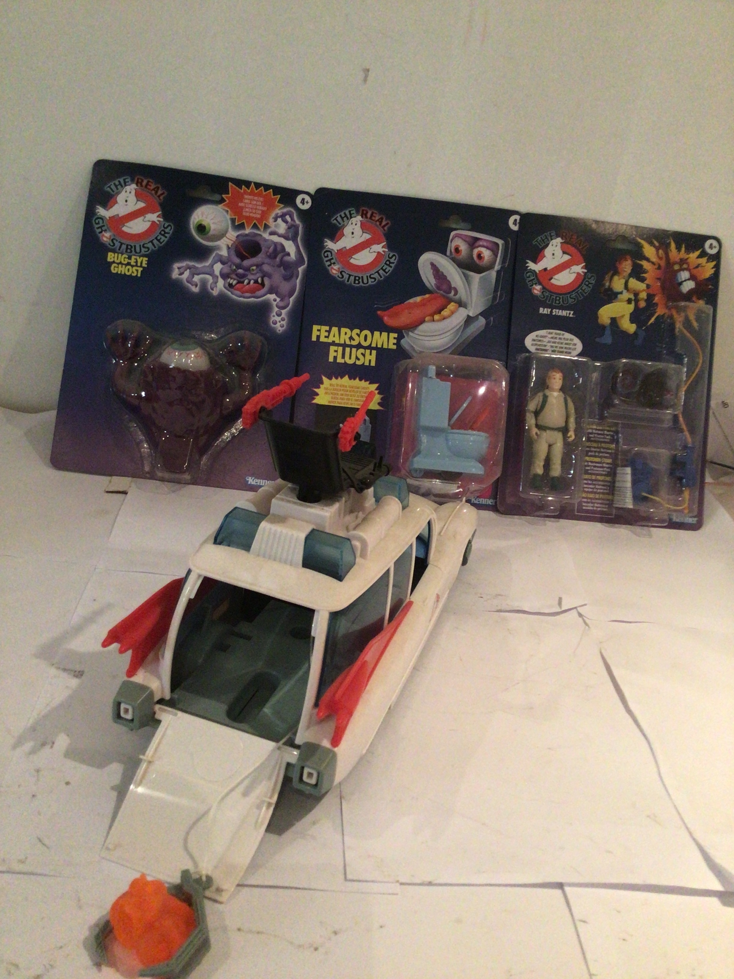 A collection of Ghostbusters figures unopened in original packaging, featuring Ray Stantz, Bug Eye ghost and Fearsome Flush. Also includes unboxed ECTO-1 with accessories.  No reserve