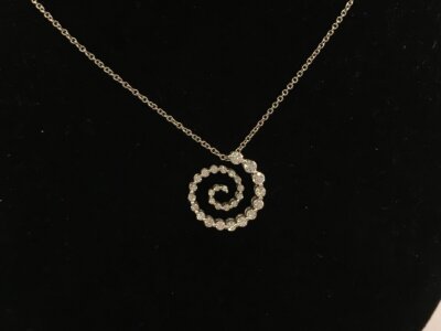 An 18ct white gold necklace with open scroll diamond set pendant also 18ct white gold.