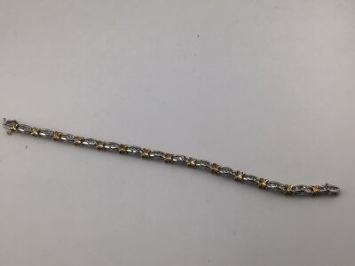 A yellow and white gold modern design bracelet each alternating link set with five brilliant cut diamonds total carat weight 1.0