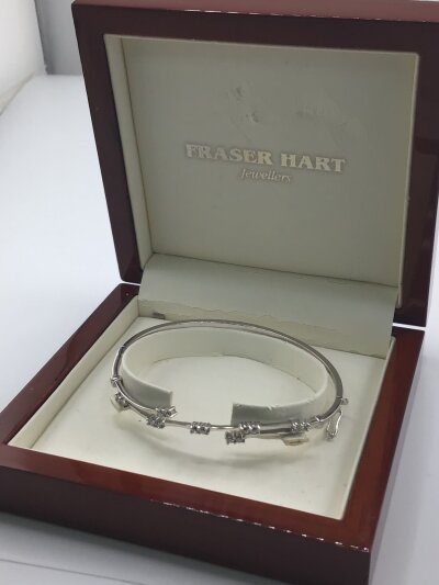 A modern design white gold 9carat bracelet set with white stones in afiited Fraser Hart jewellery box. Weight 6g
