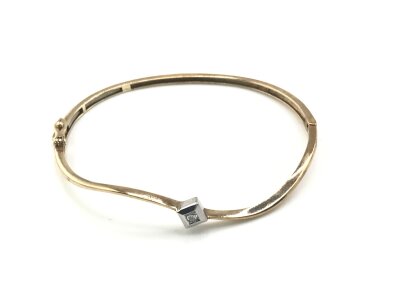 A 9ct gold bangle set with brilliant cut diamond.
8.23g and approximately 6.5cm diameter.