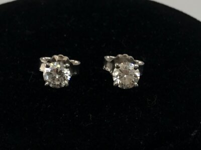 A pair of diamond solitaire stud earrings. Approximately 0.50ct each