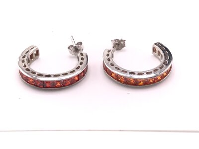 A pair of white gold earring set with vivid orange stones marked 375.
6.74g