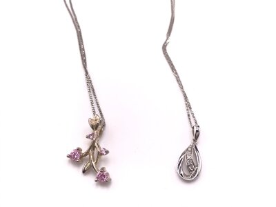 Two 9ct white gold chains with white metal pendants attached.
3.70g