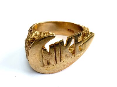 A heavy 9ct gold Nike emblem ring, Size W. 23.8g.