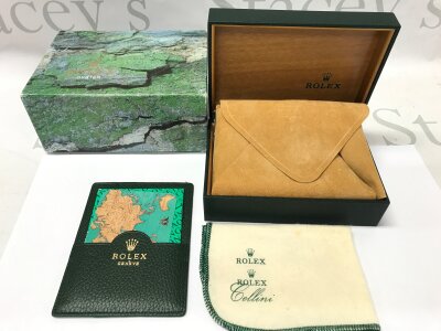 A Rolex box with a wallet and Cellini cloth.