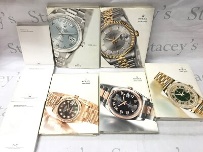 A collection of Rolex books and IWC books and pictures
