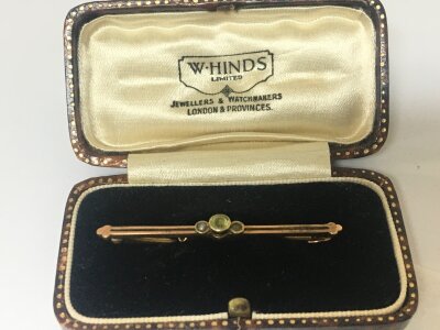 A 9carat gold brooch set with a pale green stone in a fitted  case (stone missing)