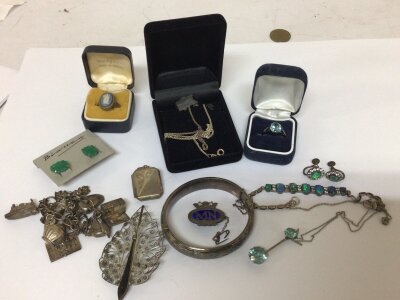 A collection of silver jewellery including a charm bracelet and bangle rings necklaces.