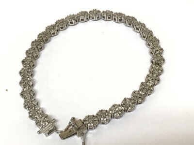 A Silver bracelet set with a repeat pattern of brilliant cut diamonds.