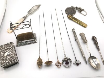 A collection of gold and silver hat pins along with a silver hat pin stands and other items including oddments.