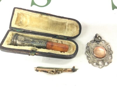A 9ct gold brooch (2g) silver watch medal pendant silver mounted amber pipe in a fitted case (3)