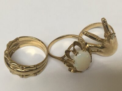 Three 9carat gold rings one in the form of a hand. An Opal doublet and one other 9carat gold ring. Weight 12.5g