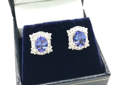 A pair of art deco style 18ct white gold oval tanzanite and RBC diamond cluster studs. Tanzanite 2.54ct and diamonds 0.54ct approx.