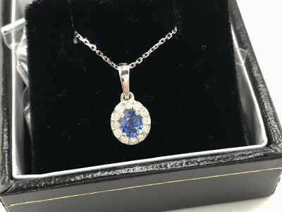 9ct white gold oval cornflower blue sapphire and diamond cluster pendant on 9ct white gold chain.