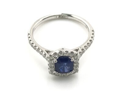 A platinum sapphire and diamond cluster ring with diamond shoulders. Step cut sapphire 1.23ct and 0.38ct diamonds approx. 
Size M