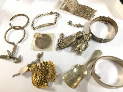 Jewellery collection including silver hallmarked bangles, silver plated character rattles, a silver 1884 American dollar , silver chain bracelet etc