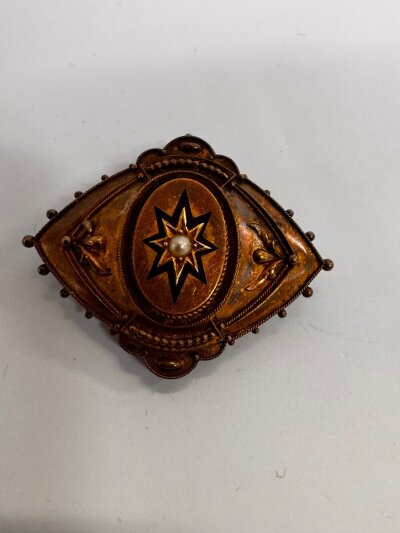 A Victorian gilt metal mourning brooch, with enamel and seed pearl decoration.