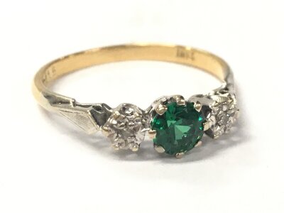 An 18ct good ring set with a green stone, 2.4g total weight. Size Q.