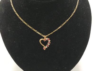 A 9ct gold chain with a 9ct gold open heart pendant set with ruby and small diamonds
3.87g